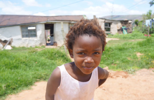 Kind bij bezoek aan township in Zuid Afrika