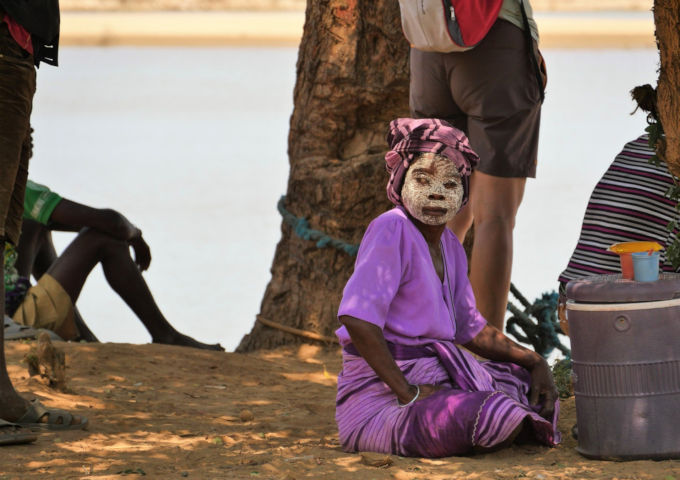 Zittende vrouw met beschilderd gezicht op Madagascar