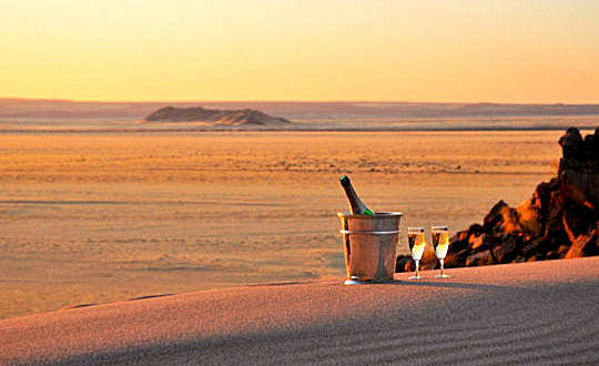 Zonsondergang met champagne in de woestijn bij huwelijksreis Namibie
