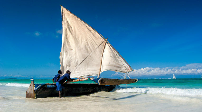 Vissers met traditionele dhow aan noordkust van Zanzibar