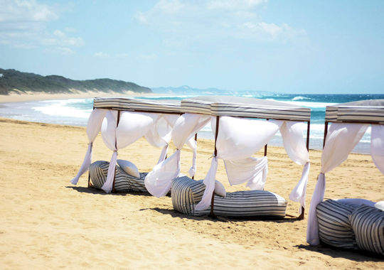 Ligbedden aan het strand bij White Pearl in Mozambique